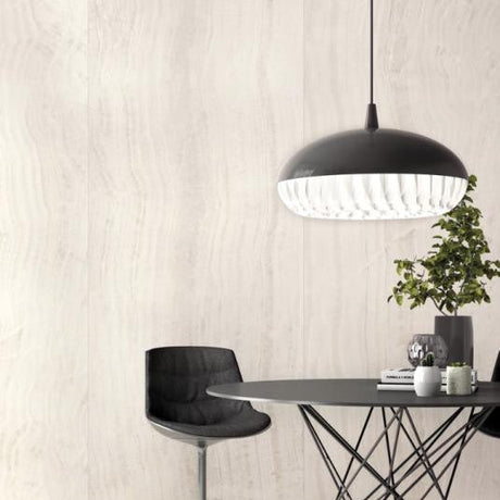 Modern dining area with a black pendant light, table, and chair against a seamless large porcelain panel wall.