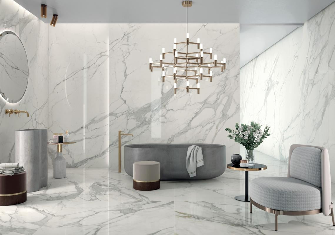 Modern bathroom with marble look porcelain tile walls, a freestanding bathtub, and decorative elements.